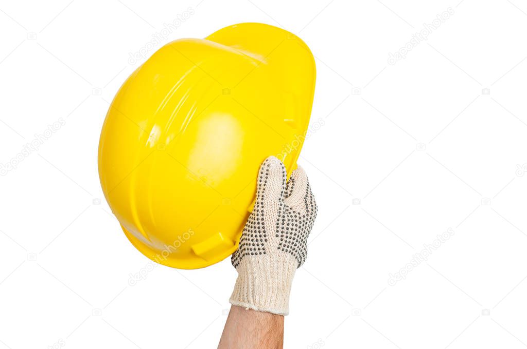 Tool. Hand in glove is holding yellow safety helmet on white background .
