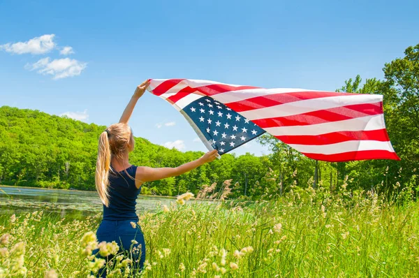 Mulher segurando bandeira americana ao ar livre. Estados Unidos celebram 4 de julho — Fotografia de Stock