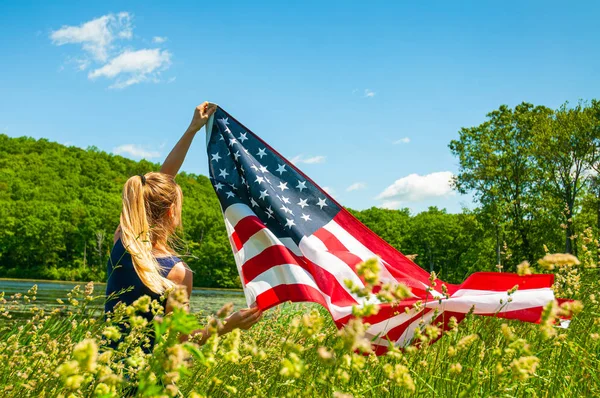 Mujer sosteniendo bandera americana al aire libre. Estados Unidos celebra el 4 de julio Día de la Independencia . — Foto de Stock