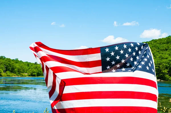 Amerykańska flaga na tle jeziora. Stany Zjednoczone obchodzą Dzień Niepodległości. 4 lipca. — Zdjęcie stockowe
