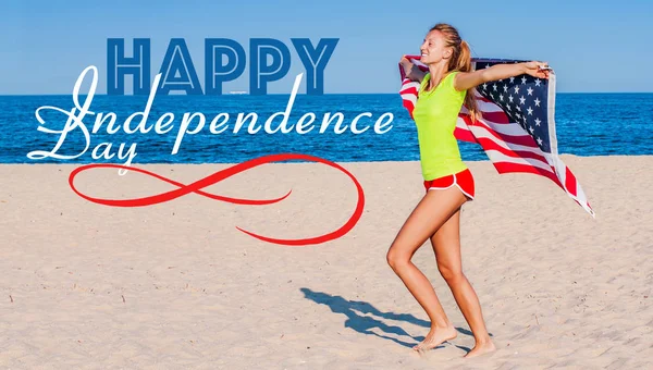 Gyönyörű vidám nő, aki amerikai zászlót a strandon. — Stock Fotó