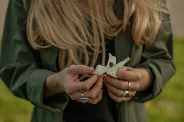 Όμορφη γυναίκα με μακριά μαλλιά κρατώντας λουλούδι. Τα χέρια με δαχτυλίδια κομψά αξεσουάρ Μπόχο. Χωρίς εστίαση — Φωτογραφία Αρχείου