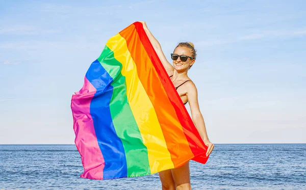 Mujer lesbiana con bandera LGBT en la playa. Bandera Gay Rainbow. Comunidad LGBT — Foto de Stock