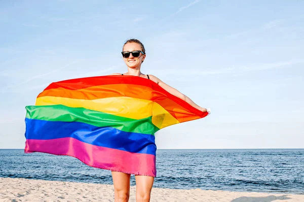 Mujer lesbiana con bandera LGBT en la playa. Bandera Gay Rainbow. Comunidad LGBT — Foto de Stock