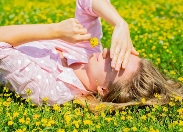 Boldog nő feküdt a területen fű, sárga virágok a szabadban. Élvezze a természetet. Allergiamentes. — Stock Fotó
