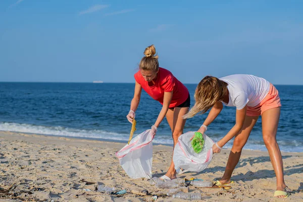 ビーチラインを掃除するボランティアのグループ。海岸でゴミを片付ける人々。エコロジーコンセプト — ストック写真