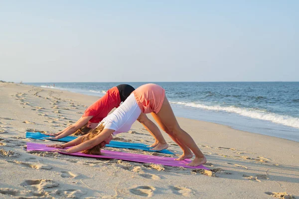 Femei tinere care practică yoga pe plajă . — Fotografie, imagine de stoc