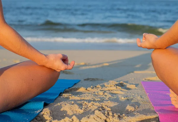 妇女练习瑜伽和冥想在海滩上。特写女手在泥拉和莲花位置. — 图库照片