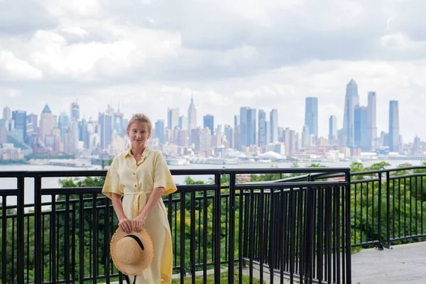 Привлекательная молодая женщина смотрит в камеру и улыбается на фоне Нью-Йорка . — стоковое фото
