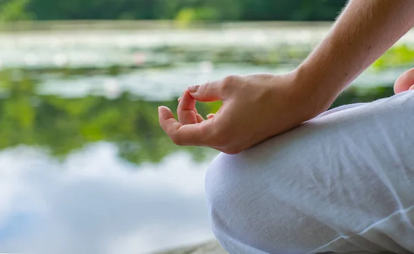 Mano femenina de cerca en posición de loto. Mujer practicando yoga y meditando . —  Fotos de Stock