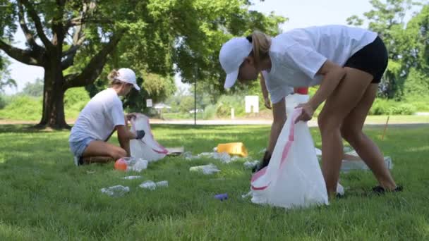 Voluntarios Limpiando Basura Parque Gente Recogiendo Una Botella Plástico Hierba — Vídeos de Stock