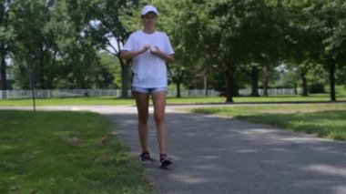 Parkta çimlerin üzerine plastik şişe atan ve giden bir kadın. Çevre kirliliği, insanlar sokağa çöp atıyor.