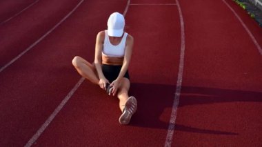 Atletik kadın koşu pistinde koşmadan önce bacaklar germe