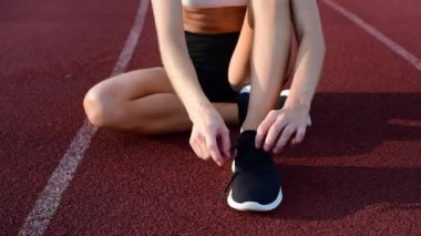 Spor ayakkabılarına ayakkabı bağcıkları bağlayan kadın koşucunun yakın çekimi