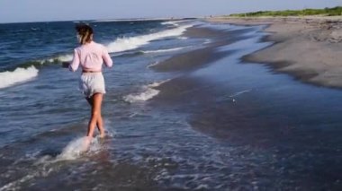 Güzel kadın yalınayak yavaş çekimde kum plajda çalışıyor. 