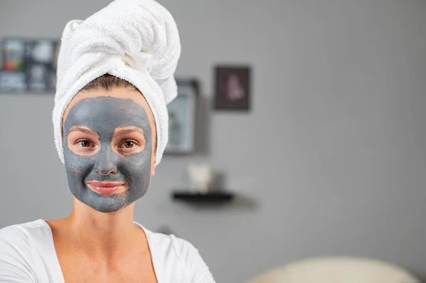 Mulher bonita está aplicando máscara de barro facial. Tratamentos de beleza e cuidados da pele — Fotografia de Stock