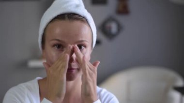 Mükemmel pürüzsüz sağlıklı bir cilde sahip güzel kadın yüzüne nemlendirici uyguluyor