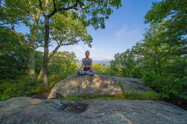 Jonge vrouw beoefenen van yoga in Lotus pose buitenshuis harmonie met de natuur. — Stockfoto