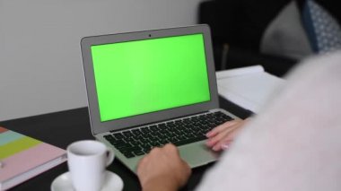 Yeşil ekranlı laptop kullanan kadın