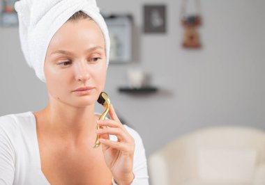 Güzel kadın anti-aging derma rulo kullanıyor. Kadın meso rulo kullanarak yüz iğne prosedürü yapıyor.