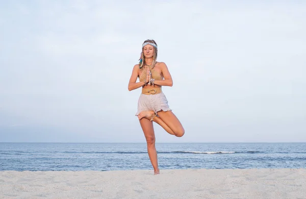 Молодая женщина практикует йогу на пляже. Поза Вршасаны — стоковое фото