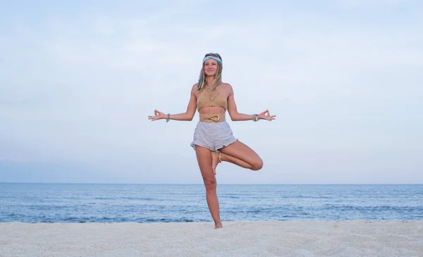 Молода жінка практикує йогу на пляжі. Вксасана позі — стокове фото
