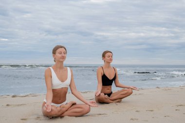 Lotus yoga genç kadınlar sahilde poz