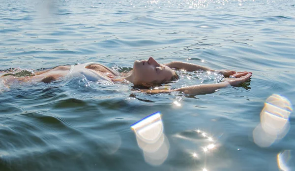 Ontspannen op het strand resort. Mooie vrouw is zwemmen op terug in zee. — Stockfoto