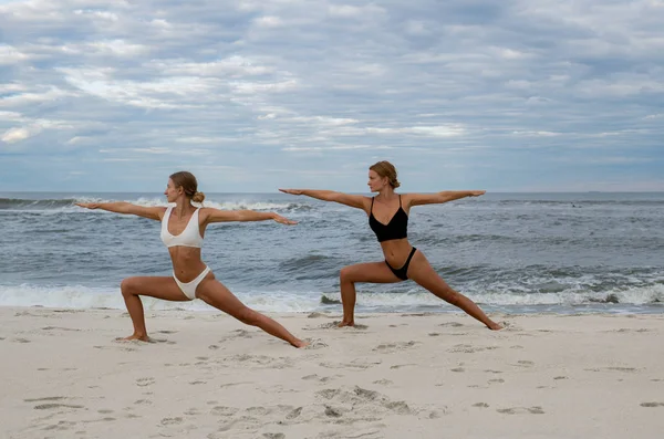 Femei tinere care practică yoga pe plajă — Fotografie, imagine de stoc