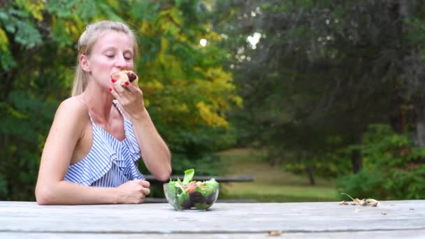 Woman Eating Hotdog Sitting Outdoors — Stock Video
