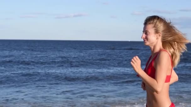 Atrakcyjna Kobieta Czerwonym Stroju Kąpielowym Biegnie Piaszczystej Plaży Zwolnionym Tempie — Wideo stockowe