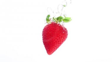 Çilek yavaş çekimde suya düşüyor. Olgun çilek suya düşer. 