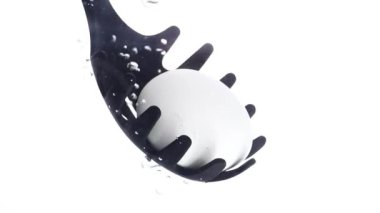 Suyun içinde yumurta kaynıyor. Tavuk yumurtaları kaynamış suya düşer. Yavaş çekim