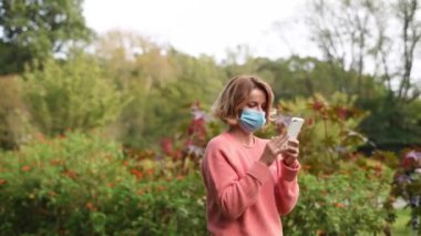 Kendine güvenen güzel bir kadın kameraya bakıyor. Park yerinde bir kadın var.