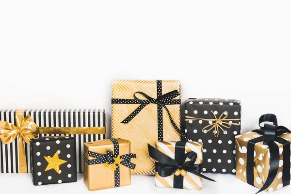Front view of gift boxes in various black, white and golden designs. Copy space. A concept of Christmas, New Year, birthday celebration event.