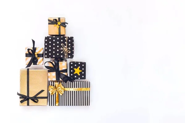 Üstten görünüm hediye kutuları çeşitli siyah, beyaz ve altın tasarımlar üçgen şeklinde düzenlenmiş Noel ağacı ya da Doğum günü pastası gibi. Noel, yeni yıl, Doğum günü kutlama olay kavramı. Yat, alanı Kopyala.