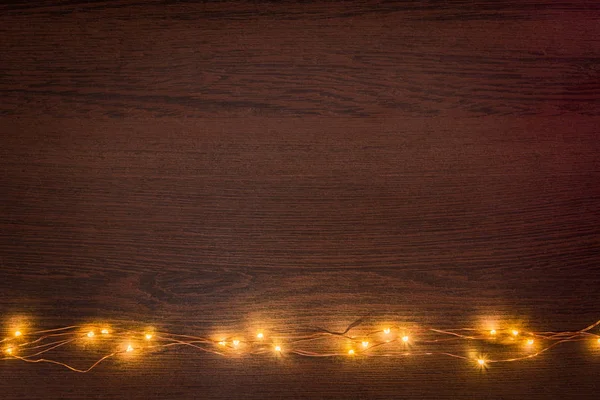 Boże Narodzenie Światła Wianek Granicy Ciemnym Tle Drewnianych Płaskie Lay — Zdjęcie stockowe