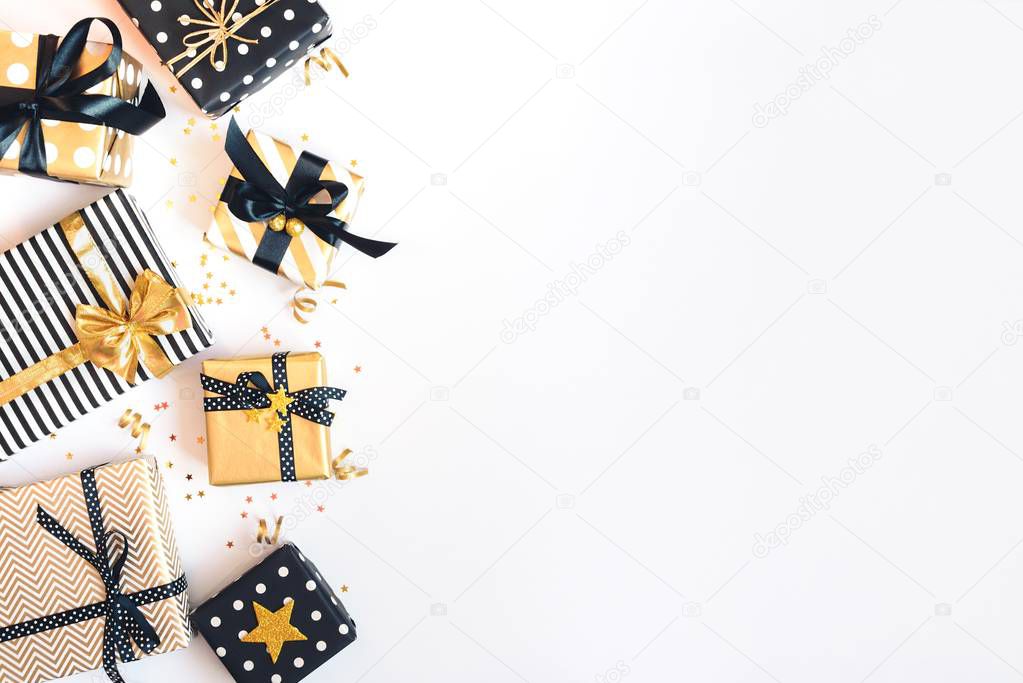 Top view of gift boxes in various black, white and golden designs. Flat lay, copy space. A concept of Christmas, New Year, birthday celebration event.
