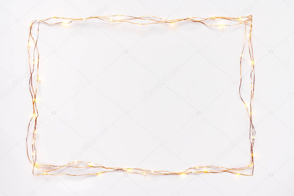 Christmas lights garland border over white background. Flat lay, copy space.