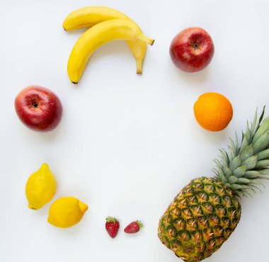 Beyaz bir arka plan üzerinde daire içinde düzenlenmiş çeşitli meyvelerüst görünümü. Kopyalama alanı.
