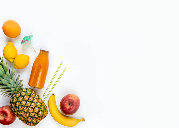 Вид сверху на различные фрукты, бутылка свежевыжатого мультивитаминового сока и коктейльные принадлежности на белом фоне. Принято. Плоский лежал
.