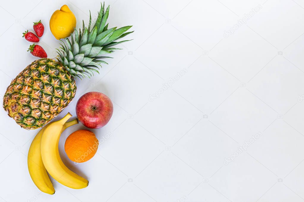 Top view of various fruits on a white background. Copy space.