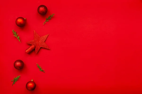 Christmas background - flat lay of red christmas balls, pine cones and fir branches over red background. Copy space. — Zdjęcie stockowe