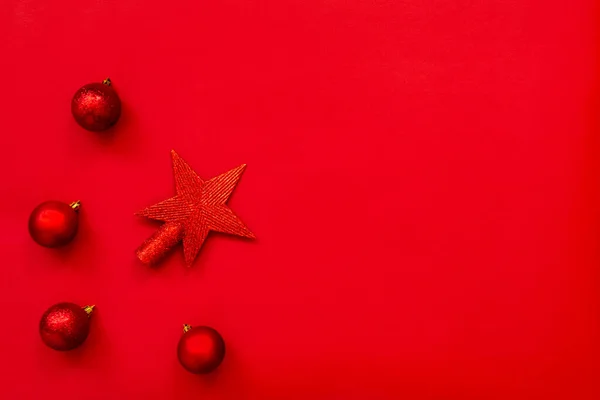 Boże Narodzenie tło - płaski układ czerwonej gwiazdy Bożego Narodzenia i piłki na czerwonym tle. Przestrzeń kopiowania. — Zdjęcie stockowe