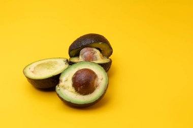 Sarı arka plana yerleştirilmiş dilimlenmiş Avokadoların yakın plan görüntüsü
