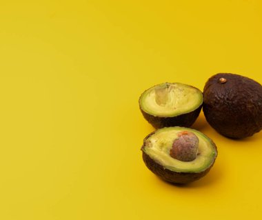 Sarı arka plana yerleştirilmiş dilimlenmiş Avokadoların yakın plan görüntüsü