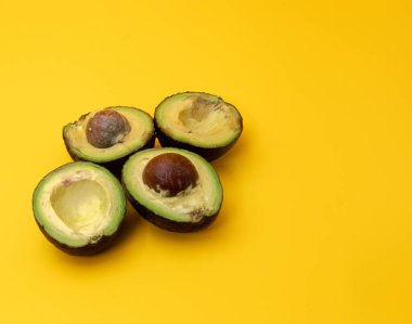 Sarı arka plana yerleştirilmiş dilimlenmiş Avokadoların yakın plan görüntüsü