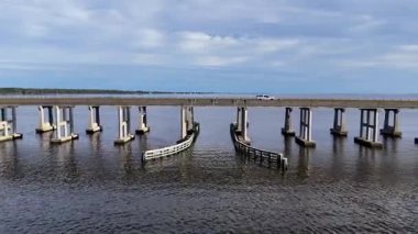 Kill Devil Hills ve Point Harbor arasında sakin bir denizi geçerek uzak ufka doğru düz bir Wright Memorial köprüsünün havadan görüntüsü. Güneş suda parlıyor, huzur verici bir sahne yaratıyor..