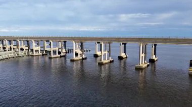Kill Devil Hills ve Point Harbor arasında sakin bir denizi geçerek uzak ufka doğru düz bir Wright Memorial köprüsünün havadan görüntüsü. Güneş suda parlıyor, huzur verici bir sahne yaratıyor..