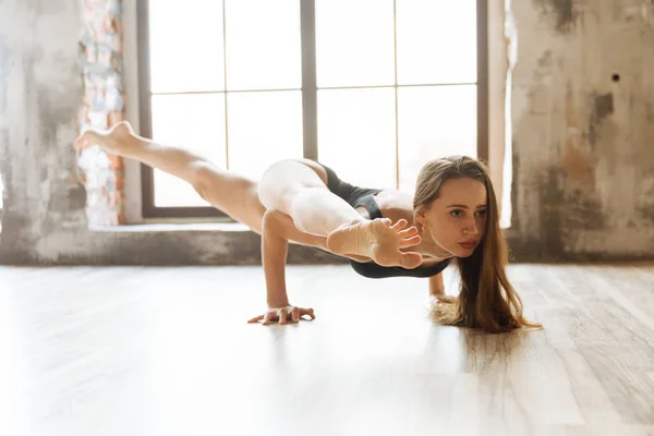 Menina yoga em um corpo preto de pé nas mãos da grande janela — Fotografia de Stock